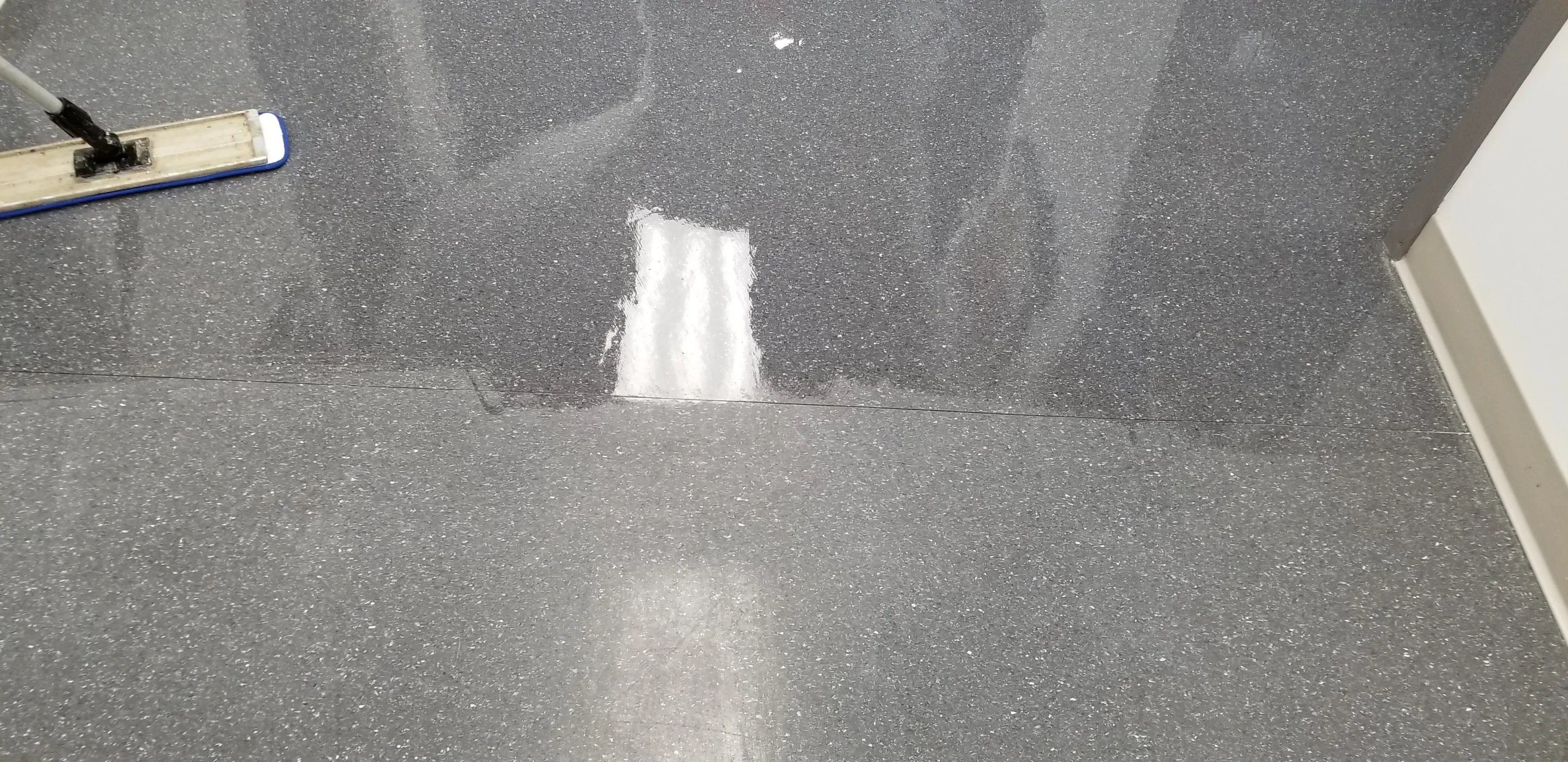 Wax being applied to a VCT floor during a strip-and-wax service